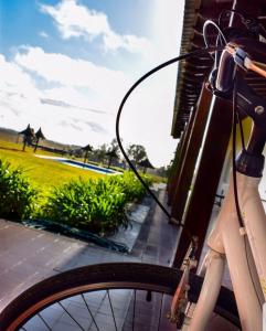杜拉斯诺圣克里斯蒂娜酒店的停在有田野的建筑旁边的自行车