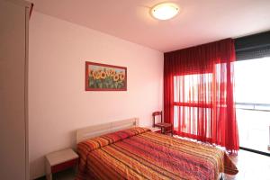 卡奥莱Panfilo的一间卧室配有床和红色窗帘的窗户