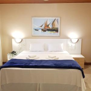 瓜拉派瑞梅阿普酒店的一间卧室配有一张大床和两条毛巾