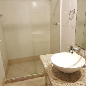 瓜拉派瑞梅阿普酒店的一间带水槽和玻璃淋浴的浴室