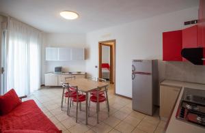 卡奥莱Robinia/Pinetine Lido Altanea的厨房配有桌椅和冰箱。