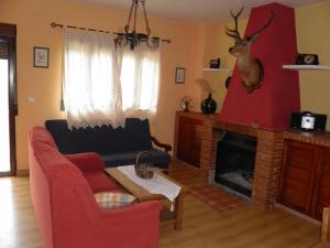卡索拉Casa el Tío Enrique的客厅设有红色的沙发和壁炉