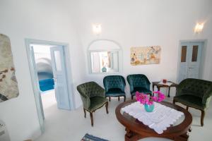 伊亚卡斯特罗伊亚别墅酒店的一间设有绿色椅子和鲜花桌子的房间