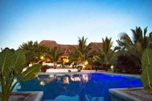 MakangalePemba Paradise的棕榈树屋前的游泳池
