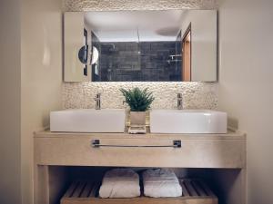 帕诺尔莫斯雷斯蒙The Royal Blue a Luxury Beach Resort的浴室设有2个水槽和2面镜子