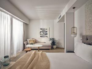帕诺尔莫斯雷斯蒙The Royal Blue a Luxury Beach Resort的一间卧室设有一张床和一间客厅。