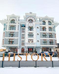 伊尔库茨克HISTORY Boutique Hotel & SPA的一座白色的大建筑,在雪中标有标志