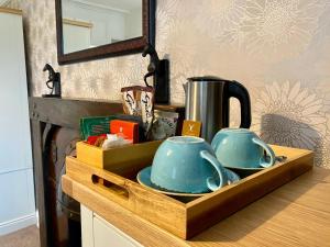 塞特尔Harts Head Hotel的木托盘,柜台上有两个茶壶