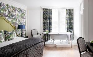 伦敦肯辛顿酒店的一间卧室配有一张床和一个窗户内的浴缸
