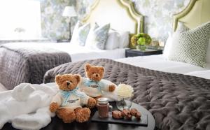 伦敦肯辛顿酒店的两个泰迪熊坐在酒店房间桌子上