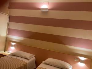 切塞纳萨维奥酒店的带条纹墙的客房内的两张床