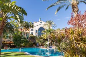 科斯塔卡玛R2里卡尔马酒店的享有棕榈树度假村和游泳池的景色