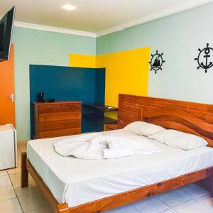 嘎林海斯港Casa Nui - Porto de Galinhas的一间卧室配有一张带白色床单和色彩缤纷墙壁的床。