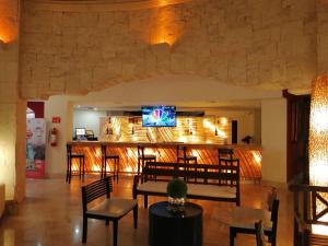 坎昆阿德哈拉哈齐恩达坎昆酒店的一个带椅子的大堂和一间带电视的酒吧