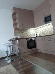 布达佩斯Rozsa55 apartment 2 rooms的厨房配有白色橱柜和桌椅