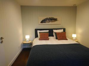 波尔特拜Isles Les Ecrehous的一间卧室配有一张带枕头的床和两盏灯。