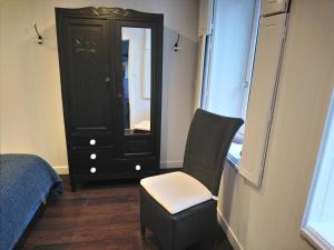 波尔特拜Isles Les Ecrehous的一间卧室配有椅子和带镜子的梳妆台