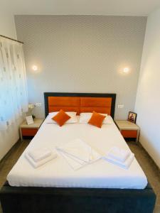 康斯坦察Orange House Constanta的卧室配有带橙色枕头的大型白色床
