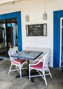 杰弗里湾Mr Pell's House Self-Catering Accommodation的一张桌子、两把椅子和墙上的黑板