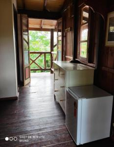 加罗帕巴Pousada Kalua Praia的一间带冰箱和开放式门的厨房