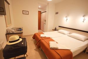 海若克利欧米拉贝洛酒店的酒店客房带两张床和一顶帽子