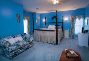 VersaillesRabbit Creek Bed & Breakfast的蓝色的卧室配有床和沙发