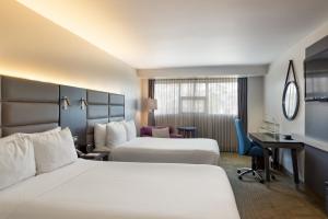 圣何塞Crowne Plaza San Jose La Sabana, an IHG Hotel的酒店客房配有两张床和一张书桌