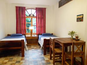 米萨华丽港香蕉山林小屋的客房设有两张床、一张桌子和一扇窗户。