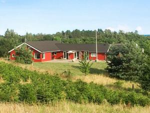 埃贝尔托夫特Holiday home Ebeltoft XI的田间中的一个红色房子