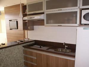 巴西利亚Duplex Apto Setor Hoteleiro Norte com serviço diário de limpeza的厨房配有水槽和白色冰箱