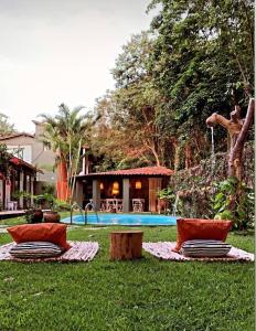 皮帕Kûara Pipa的一个带两把椅子的庭院和一个游泳池