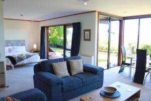 陶波Lake View Garden Apartment的客厅配有蓝色的沙发和床。