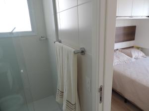圣保罗Apartamento mobiliado novo Metrô Luz的一间带玻璃淋浴的浴室和一张床