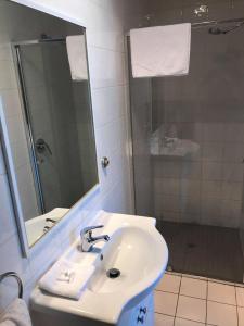 BrooklynGuiding Star Motel & Hotel的白色的浴室设有水槽和镜子
