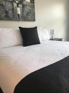 BrooklynGuiding Star Motel & Hotel的一张白色的大床,上面有黑色枕头