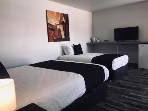 BrooklynGuiding Star Motel & Hotel的酒店客房设有两张床和一台平面电视。