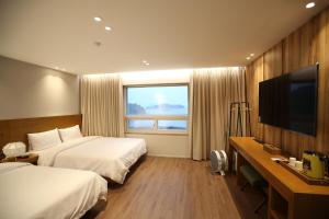 丽水市Am Ort Hotel的酒店客房设有两张床和一台平面电视。