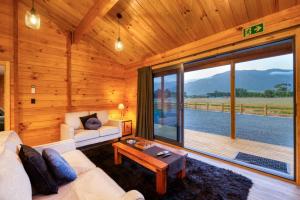 凯库拉Deerbrooke Kaikōura Chalets - Chalet 1的带沙发和大窗户的客厅