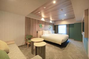 盛冈Richmond Hotel Morioka Ekimae的酒店客房,设有一张床和两张桌子