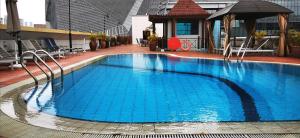 新加坡Orchard Point Serviced Apartments的一座大型蓝色游泳池,位于一座建筑的顶部