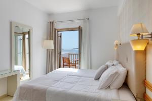 圣爱奥尼斯米科诺斯斯派罗斯&弗洛拉力托斯酒店的一间带一张白色大床的卧室和一个阳台