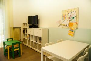 玛丽安迪安多拉Residence La Palma的一间设有桌子的教室和墙上的电视