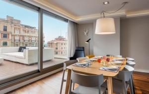 马德里Gran View Apartments的一间带桌椅和大窗户的用餐室