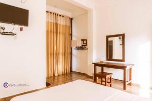 MonaragalaThe Grand Pearl Resort的酒店客房配有书桌和镜子