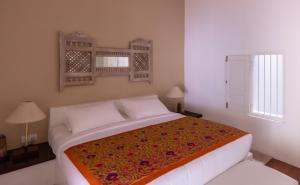 本托塔Nyne Hotels - Rock Villa, Bentota的一间卧室配有一张带彩色毯子的床