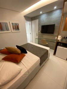 累西腓比安卡海滩酒店的一间卧室配有带枕头的床铺和电视。