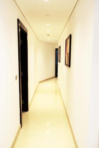 贝鲁特Staybridge Suites Beirut, an IHG Hotel的走廊设有白色墙壁和白色地板,以及黑色门