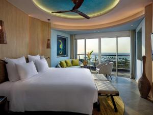 富国Pullman Phu Quoc Beach Resort的一间带大床的卧室和一间客厅