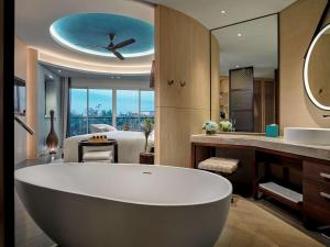 富国Pullman Phu Quoc Beach Resort的一间带大浴缸的浴室和一间卧室