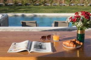 维齐纳达Villa Edoardo的一张桌子,上面放着一本书,还有一杯橙汁和面包